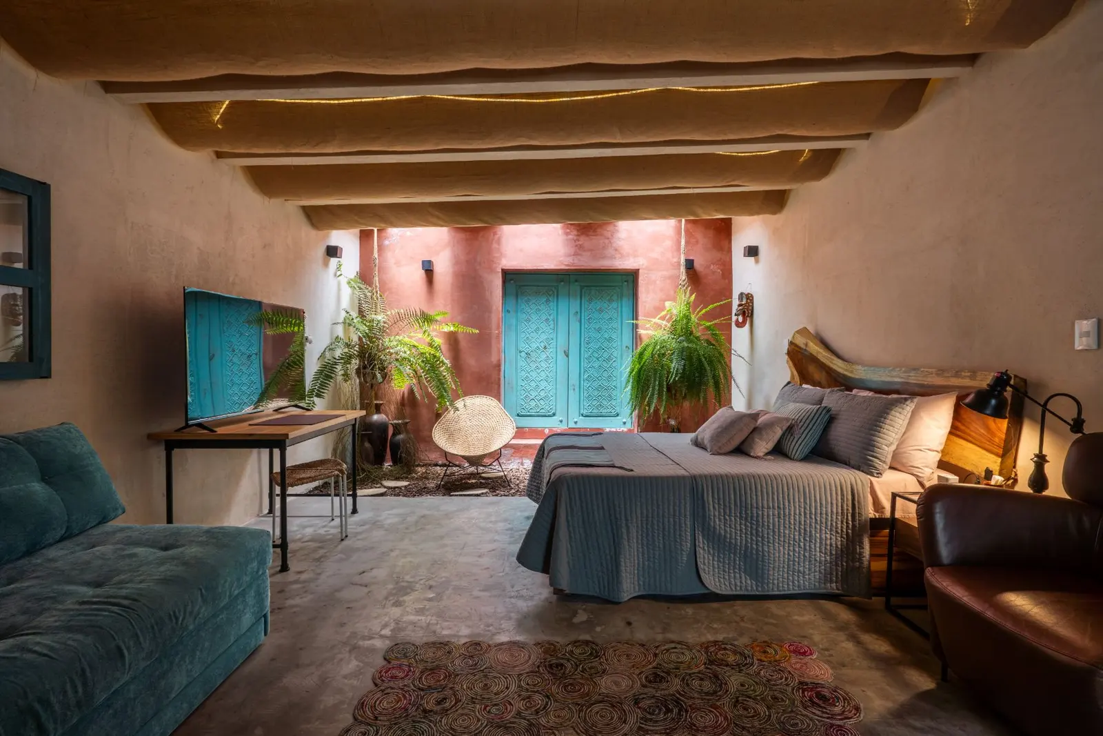 Habitación con patio de barro y puertas turquesa