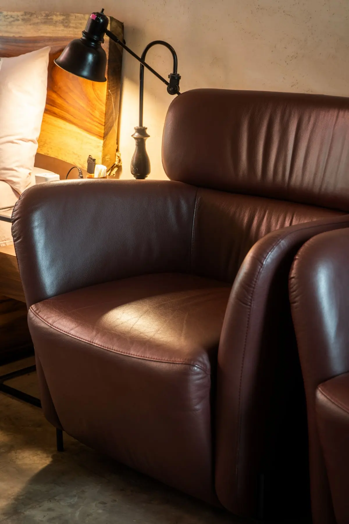 Sillón de piel junto a la cabecera de madera