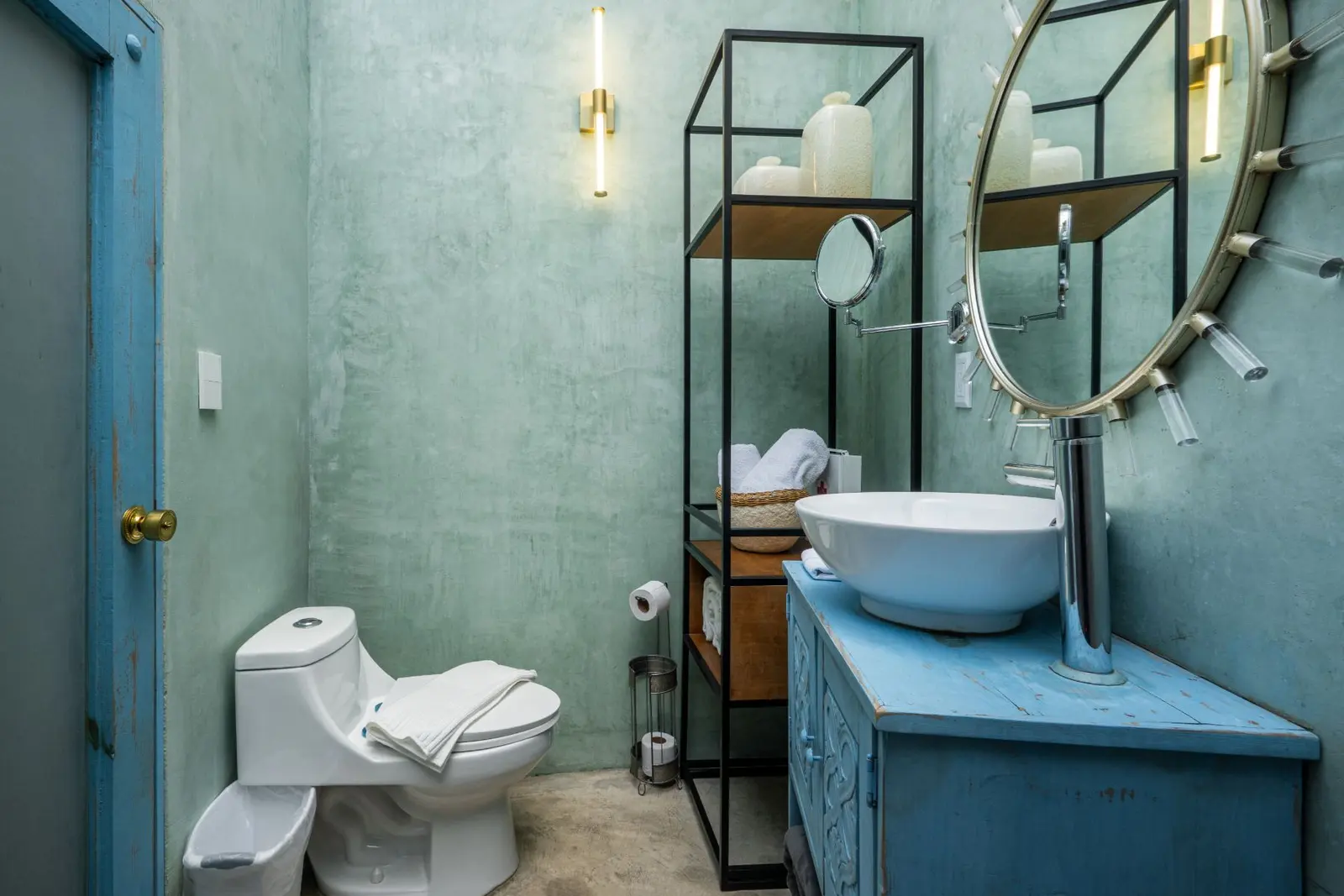 Baño con muro verde y lavabo turquesa